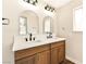 Elegant bathroom with double vanities, wood cabinets, white countertops, and arched mirrors at 1719 Rolling Hills Dr, Las Vegas, NV 89156