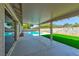 Covered patio with a view of the sparkling pool and green artificial turf in the backyard at 1719 Rolling Hills Dr, Las Vegas, NV 89156
