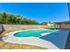 A backyard featuring a refreshing pool, artificial turf, and beautiful blooming plants at 1719 Rolling Hills Dr, Las Vegas, NV 89156