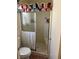 Bathroom with shower, neutral tile, built-in seat, toilet, and glass shower door at 1853 Citroen St, Las Vegas, NV 89142