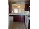 Galley kitchen featuring white appliances, tiled floors, and a sink overlooking the living room at 1853 Citroen St, Las Vegas, NV 89142