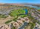 Stunning aerial view of a community with a golf course, lake, and mountain views at 20 Via Visione # 105, Henderson, NV 89011
