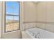 Bathtub next to a bright window showing the landscape, with a tiled surround and jets at 20 Via Visione # 105, Henderson, NV 89011