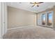 Bright bedroom featuring neutral carpet, ceiling fan, and glass doors leading to balcony at 20 Via Visione # 105, Henderson, NV 89011