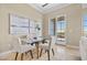 Bright dining area with a glass table, four chairs, and sliding glass doors providing access to outdoor views at 20 Via Visione # 105, Henderson, NV 89011