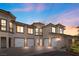 Stunning stucco home featuring a four-car garage, upper-level balconies, and manicured landscaping for added curb appeal at 20 Via Visione # 105, Henderson, NV 89011