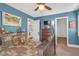 A stylish bedroom with comfortable plaid bedding, a ceiling fan and access to an ensuite bathroom at 2021 Royal Gardens Pl, North Las Vegas, NV 89084