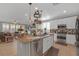 Bright kitchen boasts stainless appliances, granite countertops, and a pot rack over the island at 2021 Royal Gardens Pl, North Las Vegas, NV 89084