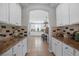Long kitchen with white cabinetry, granite countertops, and tile flooring at 2021 Royal Gardens Pl, North Las Vegas, NV 89084