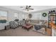 Cozy living room with neutral tones, a ceiling fan, comfortable seating, and bright natural light at 2021 Royal Gardens Pl, North Las Vegas, NV 89084