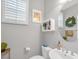 A half bathroom featuring bright natural light, a decorative mirror, and neutral tones at 2021 Royal Gardens Pl, North Las Vegas, NV 89084