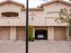 Multi-Gathering exterior featuring individual garages, warm stucco, and flowering tree at 2050 W Warm Springs Rd # 411, Henderson, NV 89014