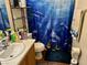 Functional bathroom featuring a vanity sink, toilet, tiled floor, and shower with dolphin shower curtain at 2130 Dragonslayer Ave, Las Vegas, NV 89183