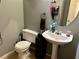 Small bathroom featuring a pedestal sink, toilet, tile flooring, and light gray walls at 2130 Dragonslayer Ave, Las Vegas, NV 89183
