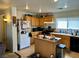 Functional kitchen with light wood cabinets, black appliances, and a central island at 2130 Dragonslayer Ave, Las Vegas, NV 89183