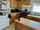 Bright kitchen featuring wood cabinets, black appliances, tile flooring, and a center island at 2130 Dragonslayer Ave, Las Vegas, NV 89183