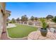 Expansive backyard with artificial turf, stone patio, and views of community landscaping at 2257 Lauren Dr, Las Vegas, NV 89134