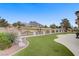 The manicured backyard with artificial turf leads to a golf course view, framed by a decorative fence and mature landscaping at 2257 Lauren Dr, Las Vegas, NV 89134