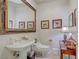 Charming powder room featuring pedestal sink, decorative mirror, and unique bird themed artwork at 2257 Lauren Dr, Las Vegas, NV 89134
