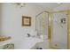 Luxurious bathtub with marble surround and glass enclosed shower with gold trim at 2257 Lauren Dr, Las Vegas, NV 89134