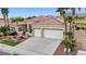 An inviting home with a tile roof, a two-car garage, and desert landscaping, including palm trees and cacti at 2257 Lauren Dr, Las Vegas, NV 89134