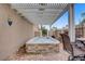 A stone-accented hot tub under a pergola, complemented by patio seating, creates a relaxing outdoor oasis at 2257 Lauren Dr, Las Vegas, NV 89134