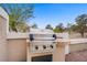A stainless steel outdoor grill is integrated into a stucco wall with a brick countertop, perfect for outdoor cooking at 2257 Lauren Dr, Las Vegas, NV 89134