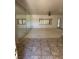 Bright living room featuring neutral walls, tile flooring, a mirrored wall, and large windows at 2562 Downeyville Ave, Henderson, NV 89052