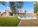 Lush backyard with a sparkling swimming pool, green lawn, desert landscaping, and a covered patio at 2620 E Harmon Ave, Las Vegas, NV 89121
