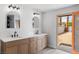 Bright bathroom featuring double sinks, modern fixtures, and access to the backyard at 2620 E Harmon Ave, Las Vegas, NV 89121