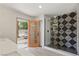 Bathroom featuring geometric tile shower, white counter, orange door, and outdoor access at 2620 E Harmon Ave, Las Vegas, NV 89121