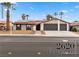 Ranch-style home with desert landscaping, solar panels, a two-car garage, and a well-maintained lawn at 2620 E Harmon Ave, Las Vegas, NV 89121