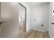 A well-lit laundry room with wood-look tile floors and access to other living spaces at 2620 E Harmon Ave, Las Vegas, NV 89121