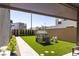 Backyard features artificial turf, a playhouse, manicured shrubs and a stone pathway between modern homes at 2650 Skylark Trail St, Henderson, NV 89044