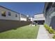 Backyard with artificial turf, playhouse and stone pathway leading to modern home featuring covered patio at 2650 Skylark Trail St, Henderson, NV 89044