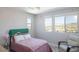 Bright bedroom featuring large windows with views, a comfortable bed, and a cozy armchair at 2650 Skylark Trail St, Henderson, NV 89044