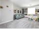 Bright bonus room features a soft blue couch, custom shelves with cabinets, and neutral color scheme at 2650 Skylark Trail St, Henderson, NV 89044