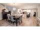 Open dining area flowing to kitchen, featuring modern table, chairs, cabinets and statement lighting at 2650 Skylark Trail St, Henderson, NV 89044