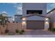 Charming home exterior with a two-car garage, modern lighting, and landscaping, creating an inviting curb appeal at 2650 Skylark Trail St, Henderson, NV 89044