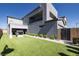 Modern two-story home features a gray exterior with a balcony, a playhouse, and manicured landscaping in the backyard at 2650 Skylark Trail St, Henderson, NV 89044