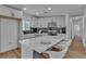Bright kitchen features modern gray cabinetry, black backsplash, stainless appliances and a large quartz island with seating at 2721 Bruce Cir, North Las Vegas, NV 89030