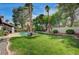 Lush backyard with a well-kept lawn, mature trees, and a serene pool area at 3151 Coachlight Cir, Las Vegas, NV 89117