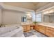 Bathroom featuring dual sinks, a vanity area, and a large soaking tub at 3151 Coachlight Cir, Las Vegas, NV 89117