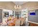 Dining room featuring a wood table, chandelier, and view into the living room and kitchen at 3151 Coachlight Cir, Las Vegas, NV 89117
