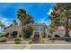 Stunning two-story home featuring a tile roof, landscaped yard, and a striking red double-door entryway at 3151 Coachlight Cir, Las Vegas, NV 89117