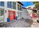 Beautiful home featuring a red front door, well-kept landscaping, and a cozy seating area on a brick-paved patio at 3151 Coachlight Cir, Las Vegas, NV 89117