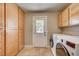 Functional laundry room with ample storage cabinets, a convenient door, and modern washing machines at 3151 Coachlight Cir, Las Vegas, NV 89117