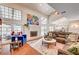 Spacious living room with brick fireplace, french doors, high ceilings and open layout to the kitchen at 3151 Coachlight Cir, Las Vegas, NV 89117