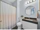 Bright bathroom featuring a modern vanity, stylish lighting, and a shower with a colorful patterned curtain at 3171 Biccari Ave, Henderson, NV 89044