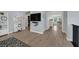 Bright hallway featuring wood-style tile floors, wall-mounted TV, and an open floorplan to other rooms in the house at 3171 Biccari Ave, Henderson, NV 89044